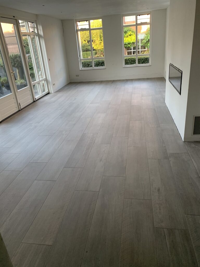 Woonkamer met grijze tegelvloer in houtlook