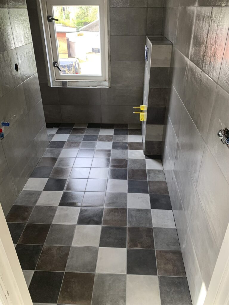 Badkamer met patchworktegels in grijstinten