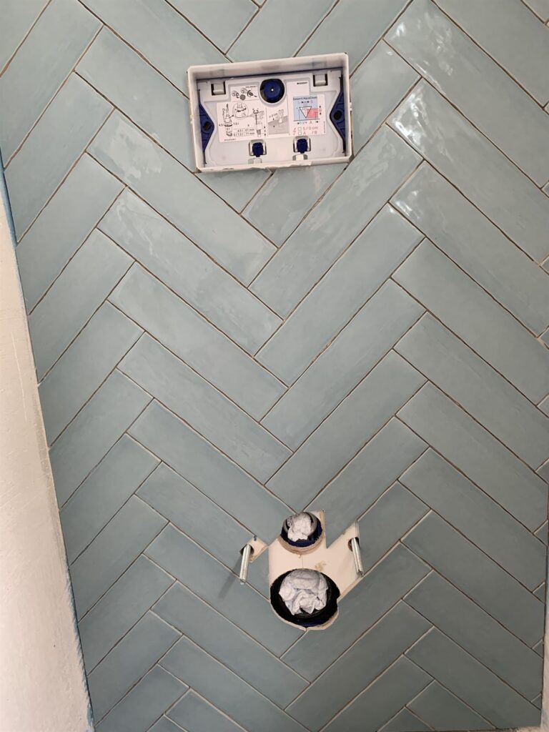 Toilet met mintgroene tegels in visgraatpatroon